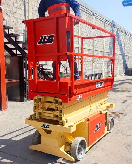 Outdoor scene with multiple blue aerial lifts and heavy machinery in a sunny industrial area.